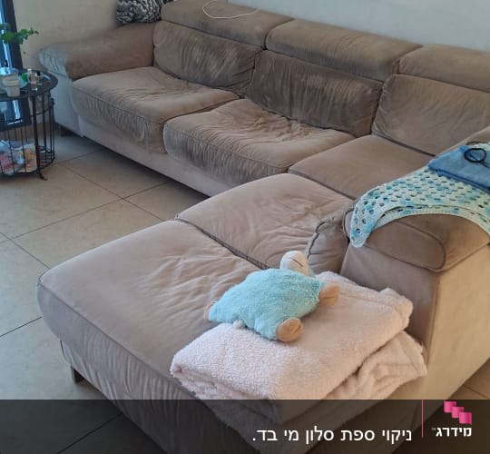 ספה עם כריות ושמיכה על הרצפה